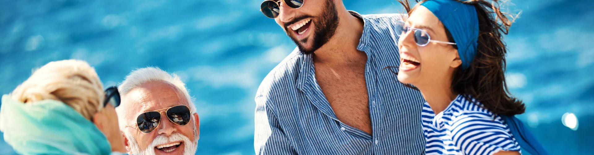 Gruppe von Freunden, die am Meer lachen und Spaß haben.