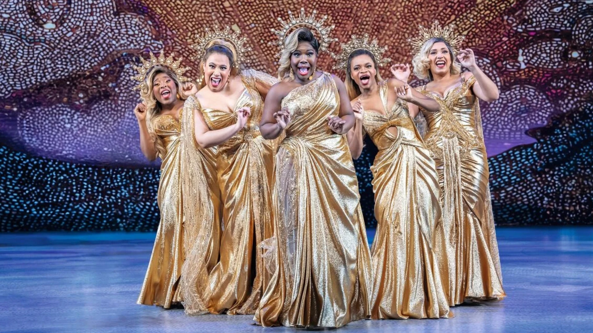 Die fünf Musen in goldenen Gewändern bei einer Gesangsperformance im Musical Hercules, Szenenmotiv