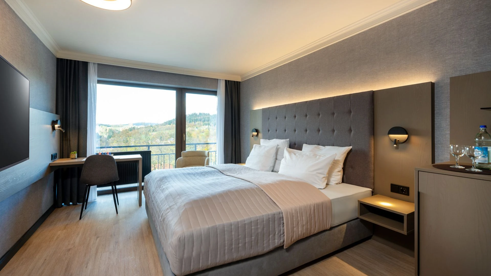 Modernes Hotelzimmer mit Balkon und schöner Aussicht auf die Landschaft.