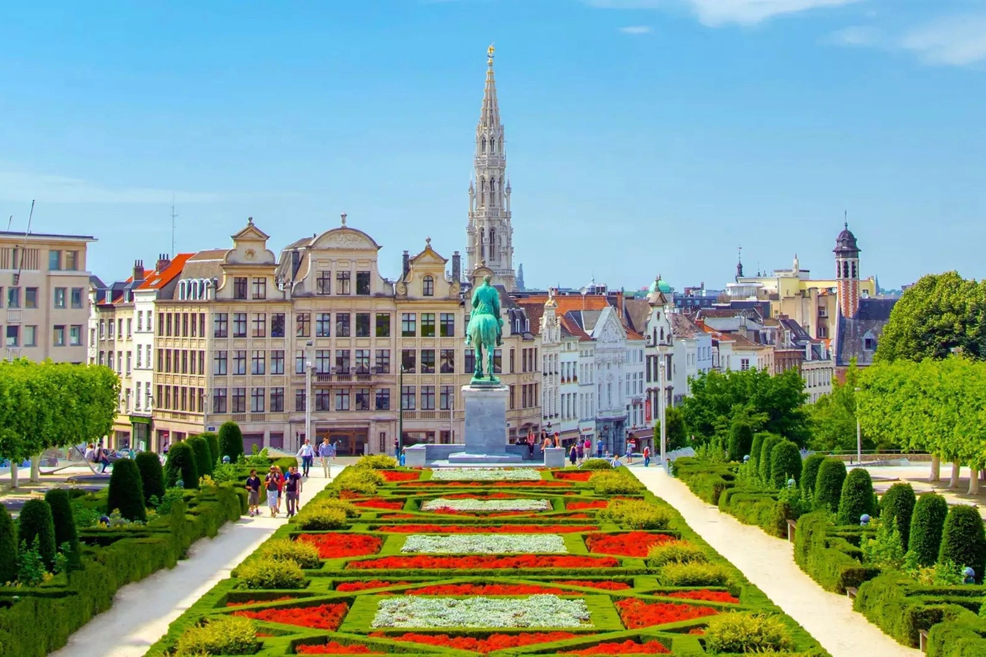 Mont des Arts in Brüssel, eine wunderschöne Parkanlage mit Blick auf die Nationalkathedrale bei sonnigem, klarem Wetter, umgeben von blühenden Gärten und kunstvollen Stufen.