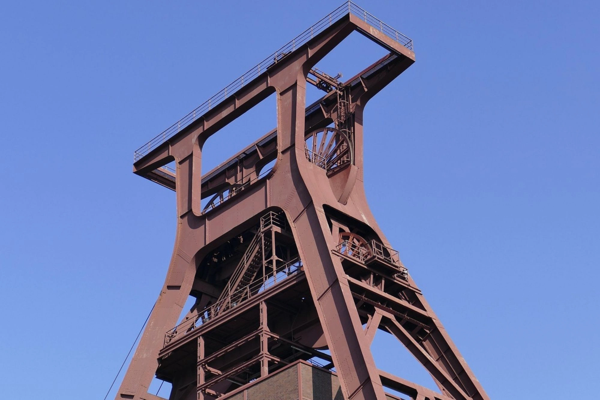 Förderturm einer Zeche aus Stahl mit komplexer Konstruktion vor blauem Himmel
