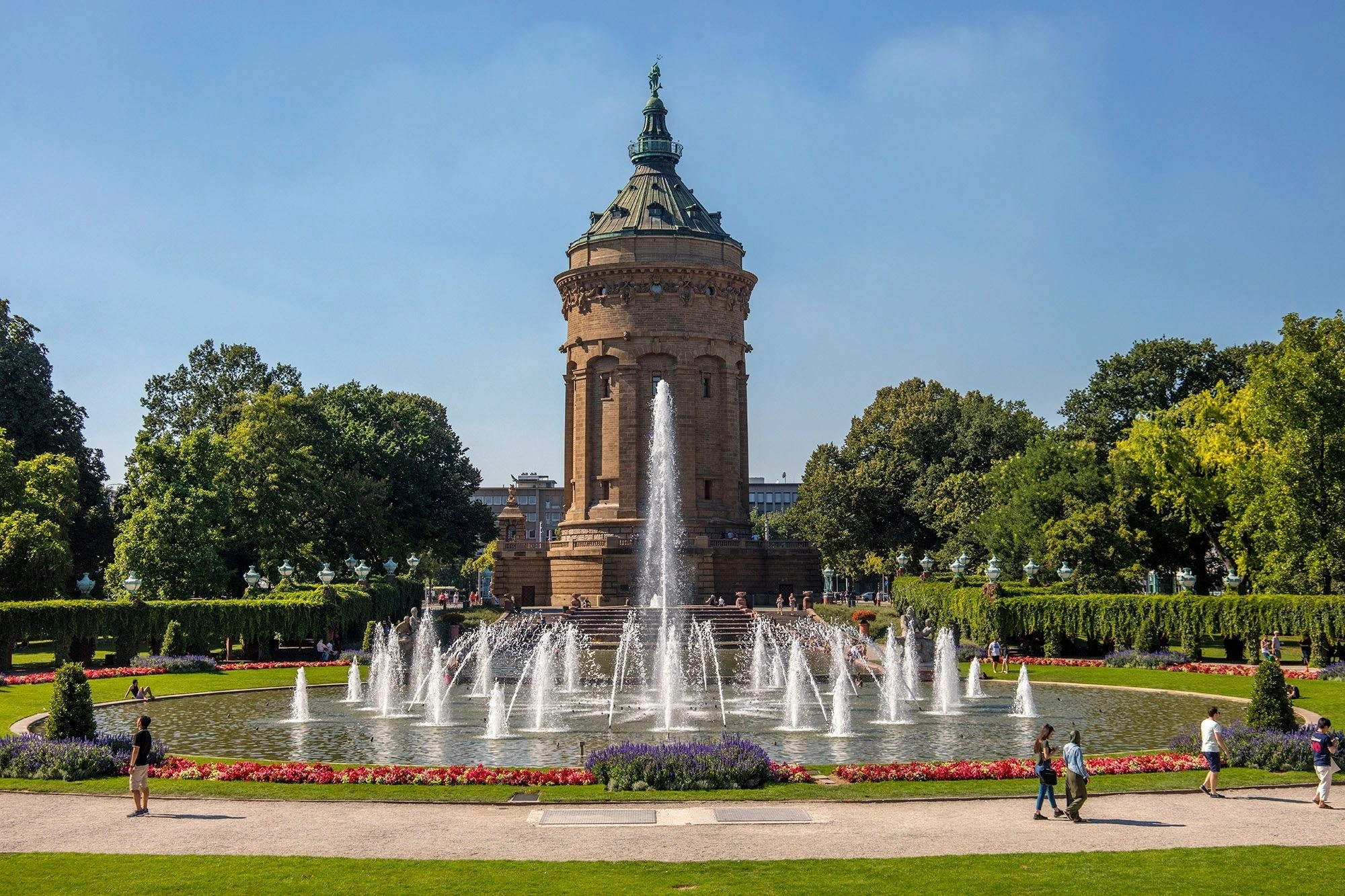 Historischer Brunnen im Park von Mannheim mit bunten Blumen