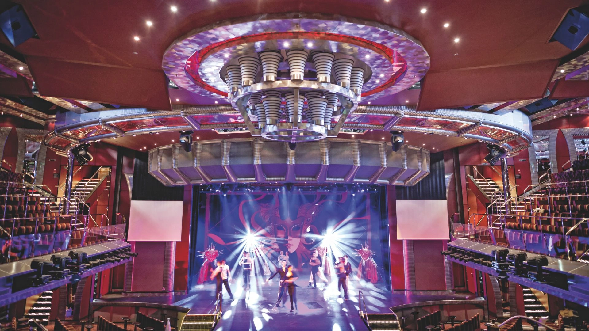 Aufführung auf der Bühne mit bunten Lichtern und Tänzern.