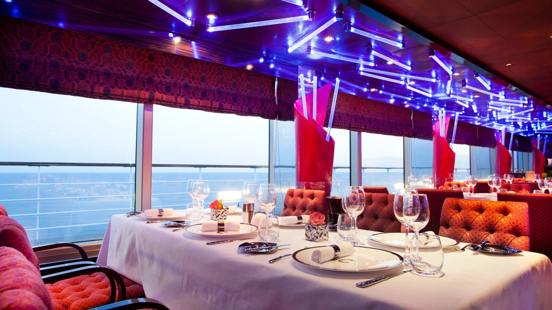 Elegantes Restaurant mit Blick auf das Meer und stilvoll gedecktem Tisch.