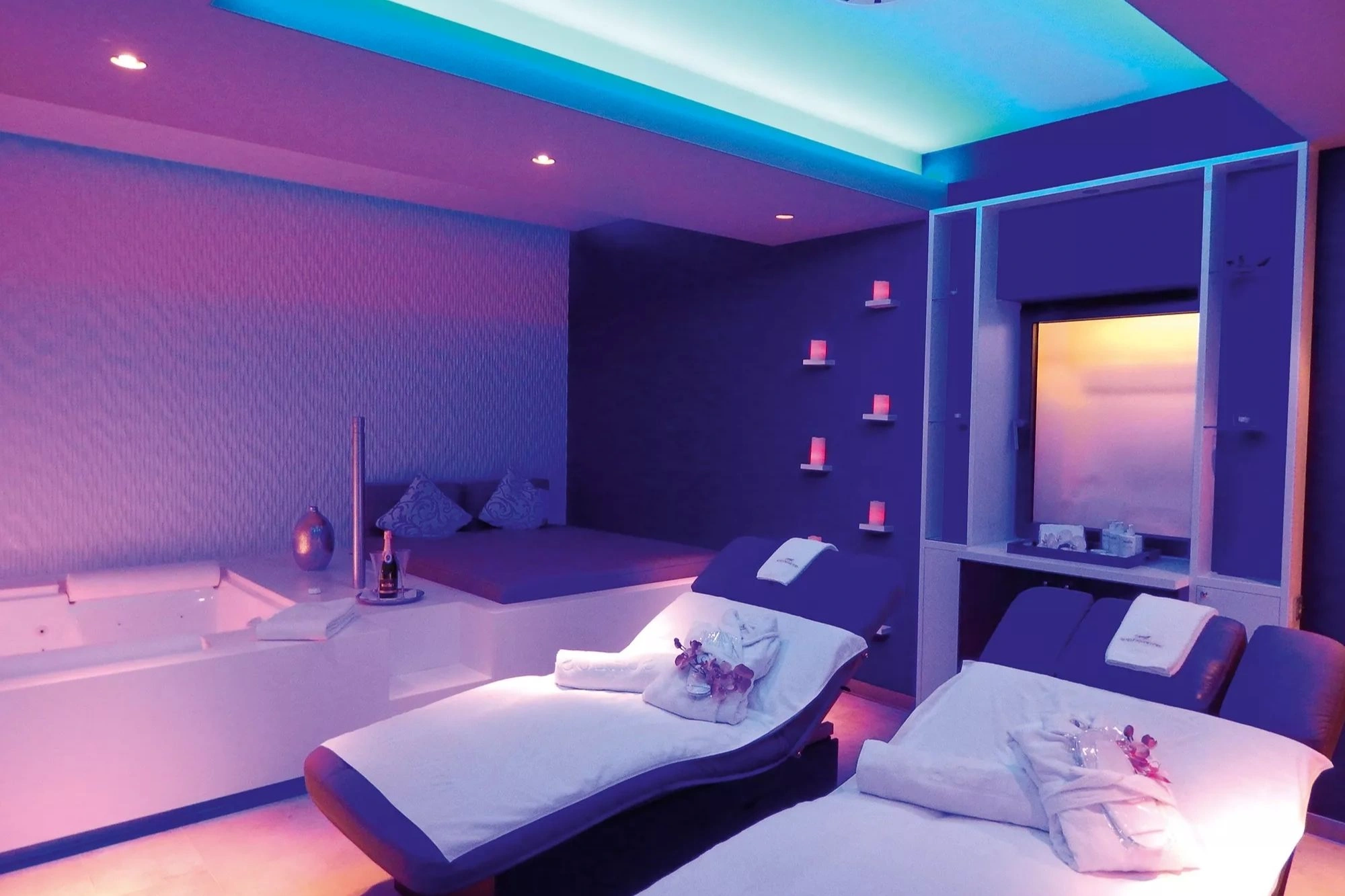 Luxeriöser Behandlungsraum für Wellnessanwendungen im Schlosshotel Bad Wilhelmshöhe mit Liegen und Badewanne in verschiedenen violetten Farbtönen