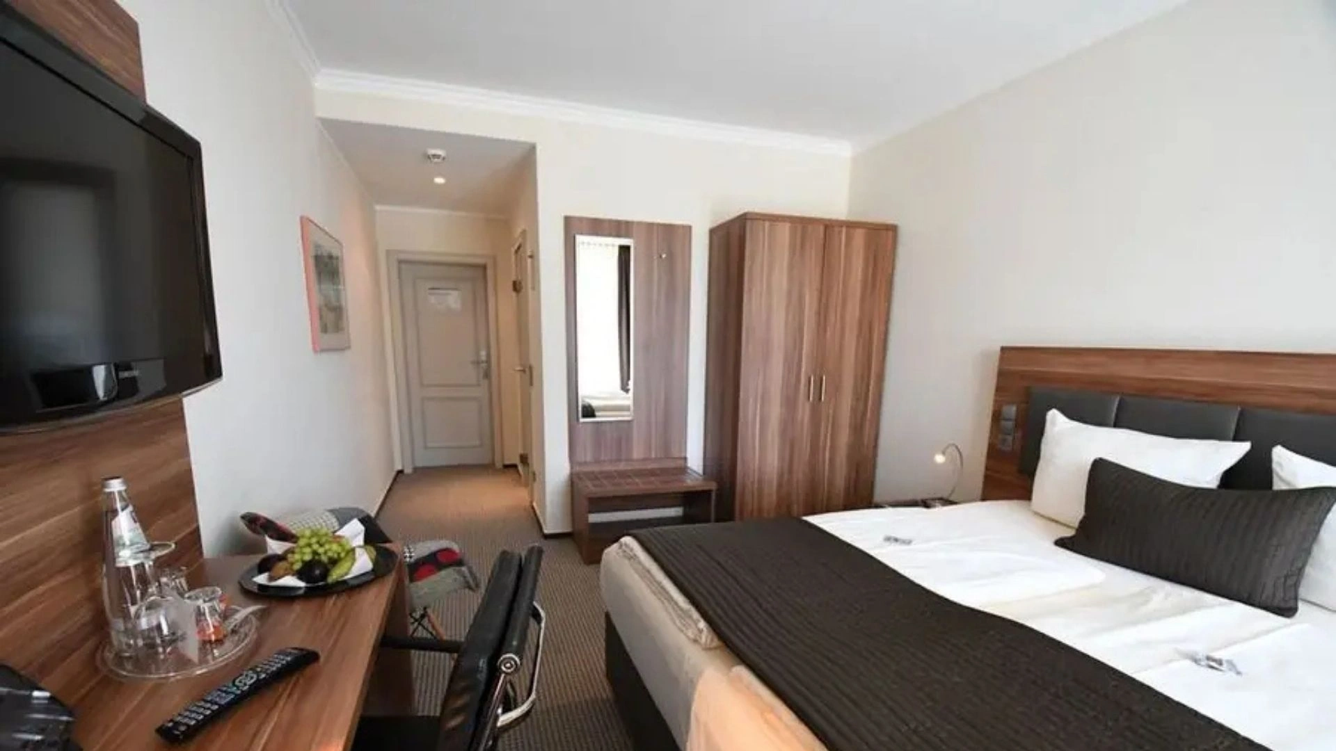 Beispielzimmer der Kategorie Comfort im Schlosshotel Bad Wilhelmshöhe (Doppelbett, Schreibtisch, Schrank und Garderobe)