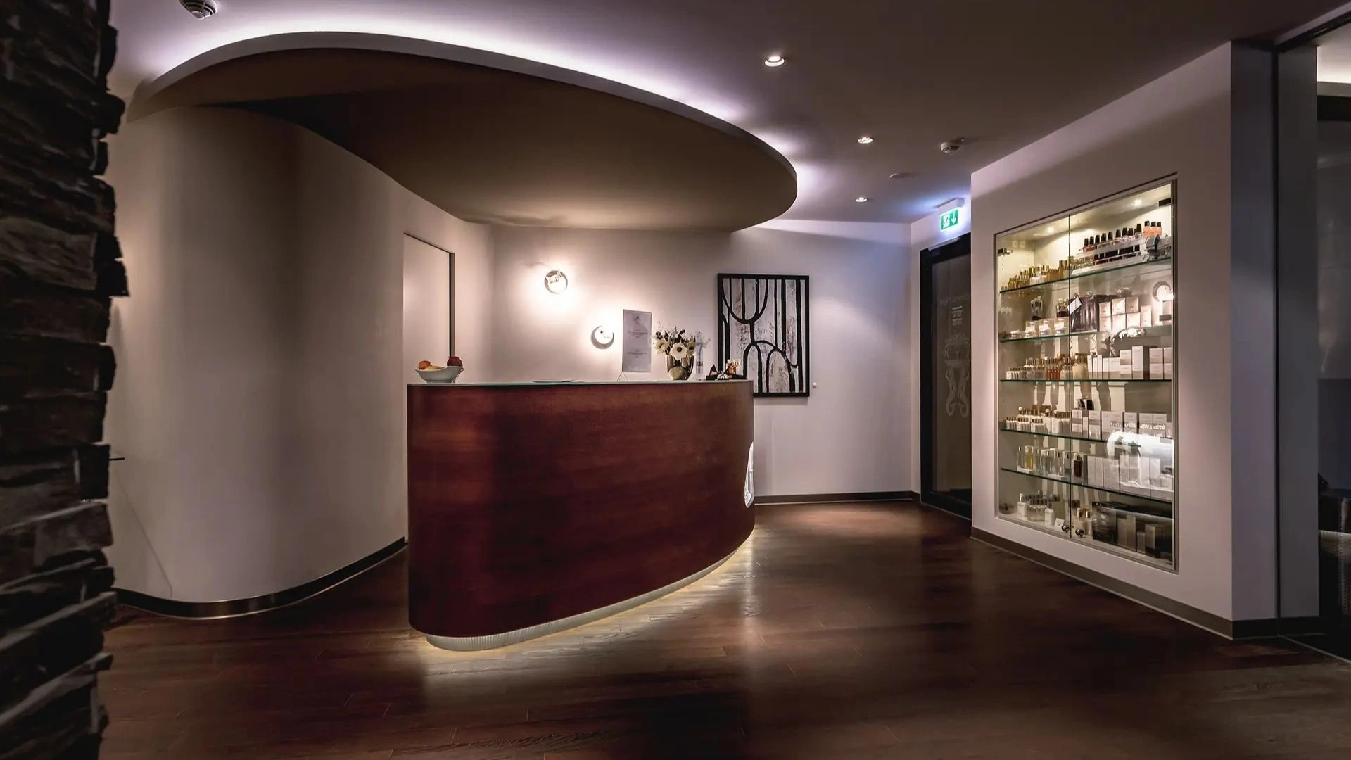 Spabereich in Holzoptik mit Tresen und Pflegeprodukten in der Vitrine