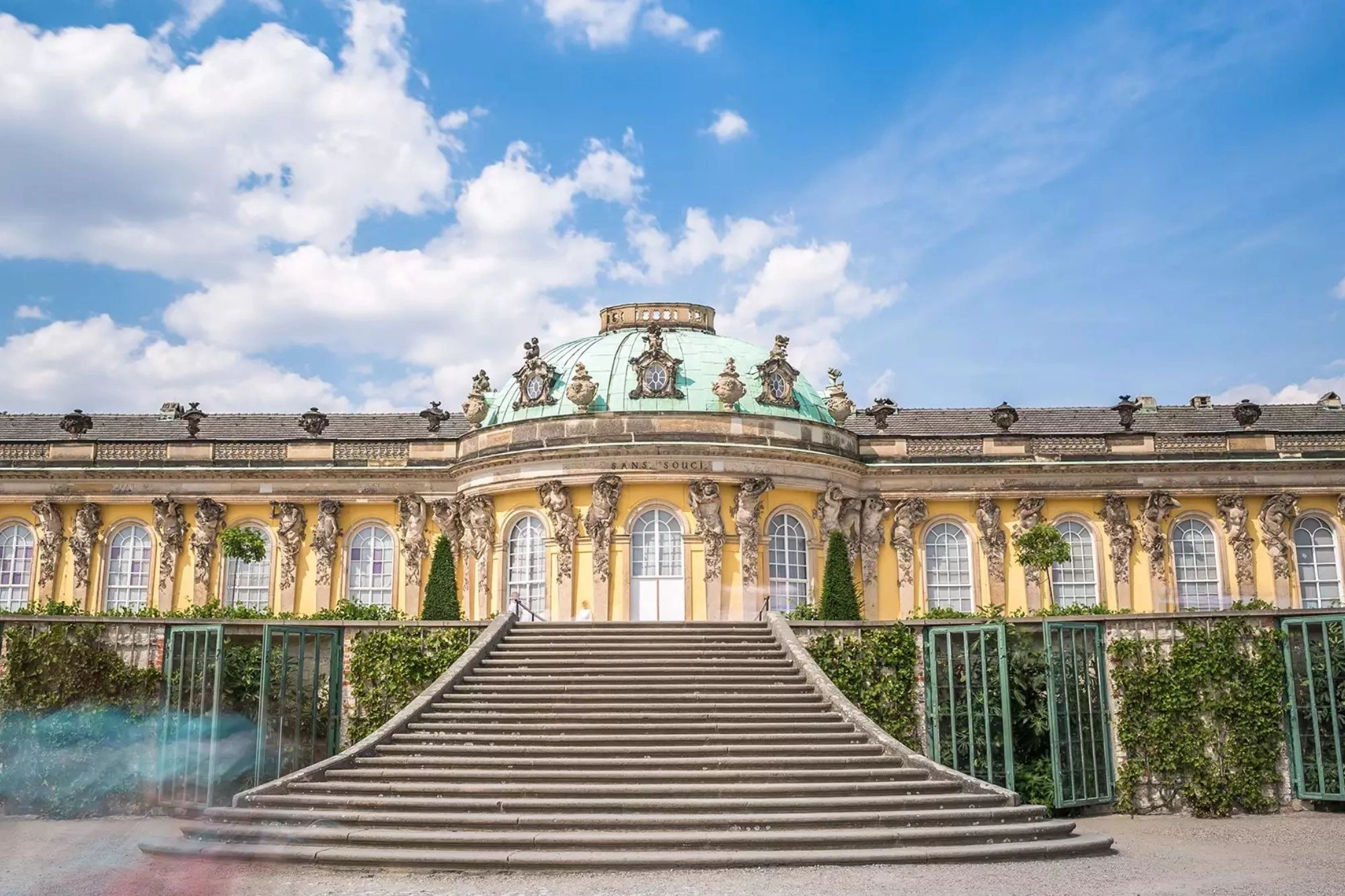 Schloss Sanssouci in Potsdam mit großer Freitreppe bei Sonnenschein