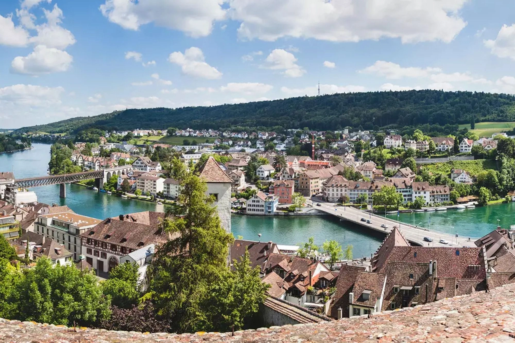 sonniger Panoramablick bei einer Reise nach Schaffhausen mit Hotel - der Rhein im türkis schlängelt sich durch die Stadt