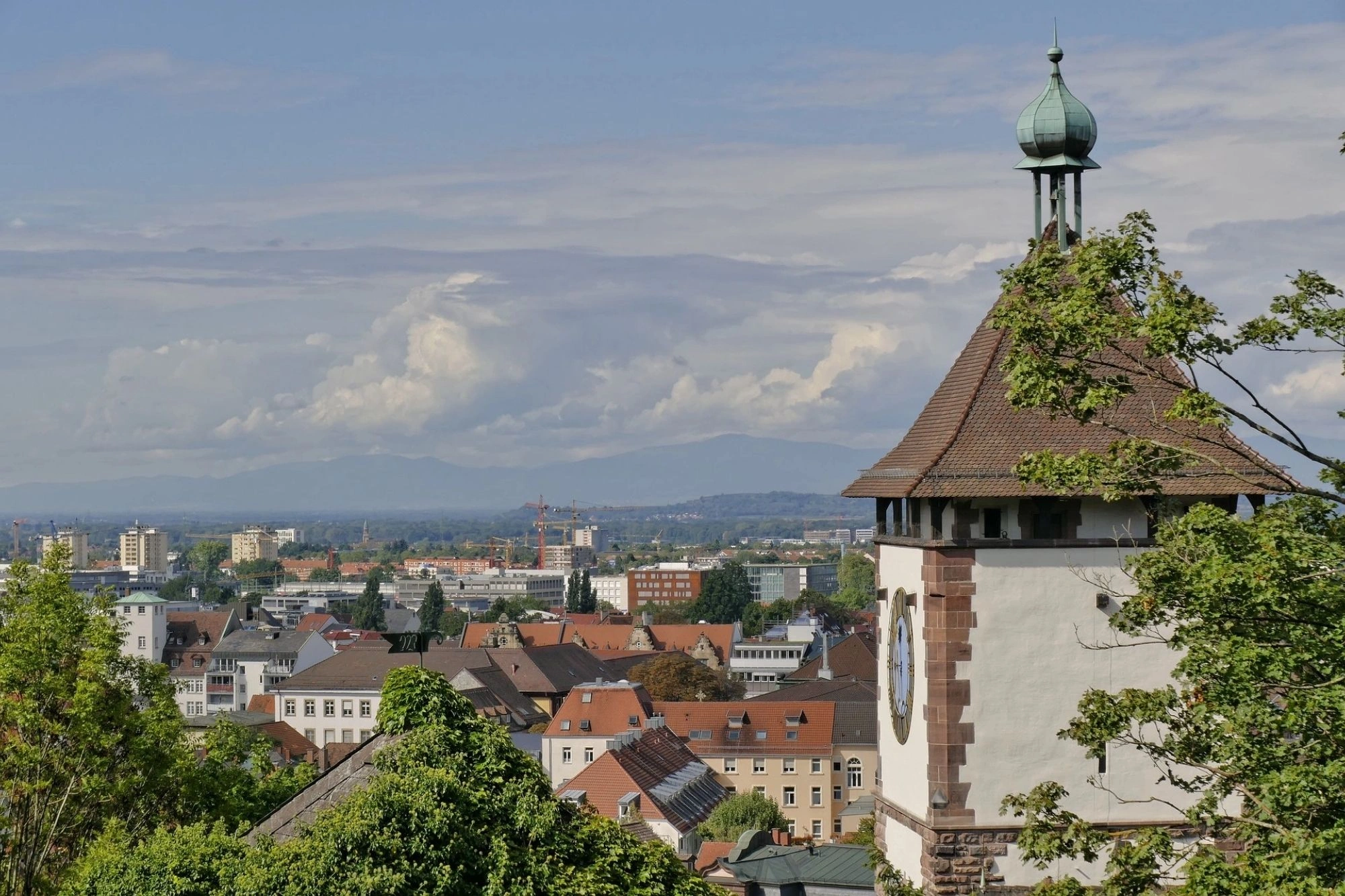 Panoramablick auf Freiburg mit dem Schwarzwald im Hintergrund.