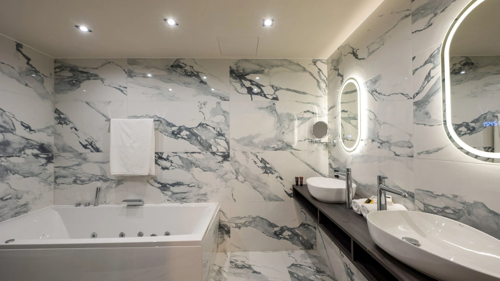 Modernes Badezimmer mit Marmorfliesen und eleganter Beleuchtung