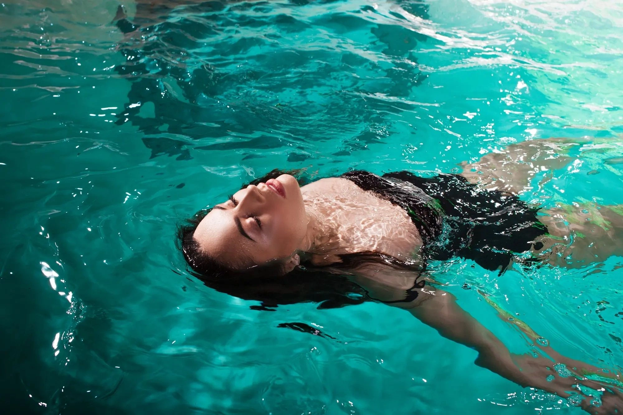 Frau relaxt im Pool des Wellness & Spa Bereiches ihres Wellness Hotels