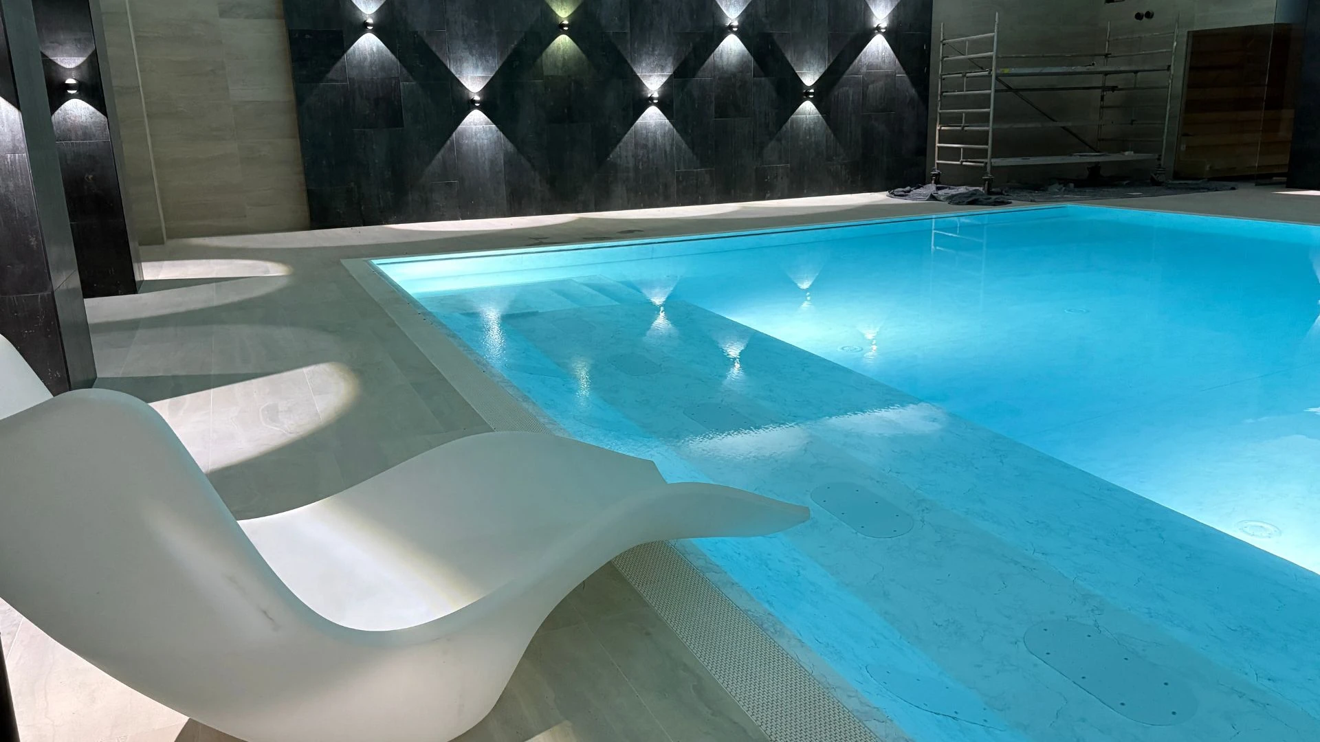 Eleganter Innenpool mit modernem Design und stilvollem Stuhl.