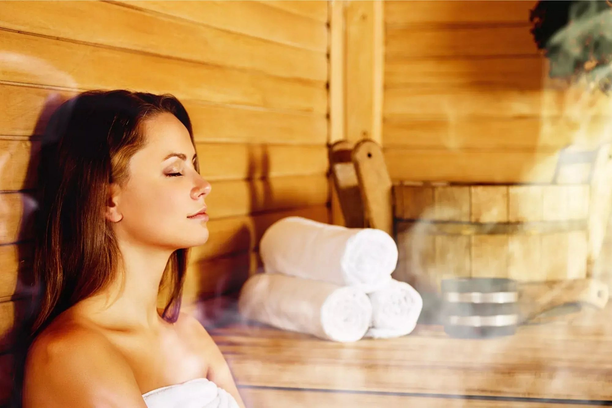 Junge Frau in der dampfenden Sauna im Wellness Urlaub