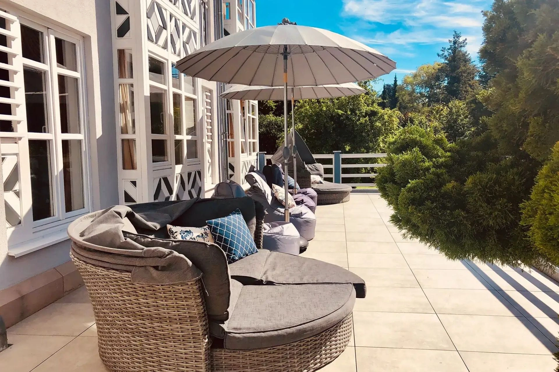 Sonnenterrasse mit Liegeinseln und Sonnenschirmen im Romantisches Hotel Menzhausen