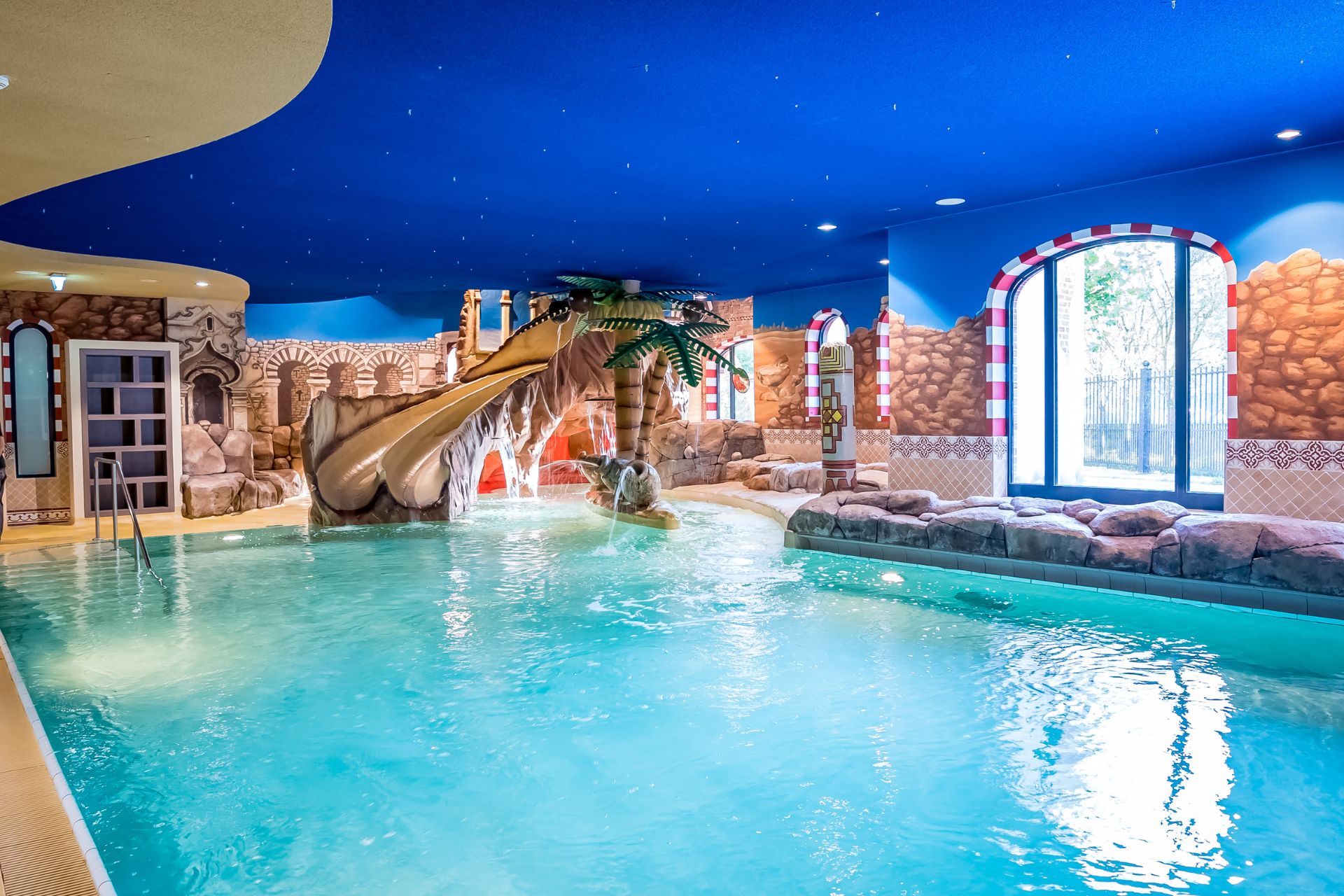 Schwimmbad mit einer aufregenden Wasserrutsche und dekorativen Wänden