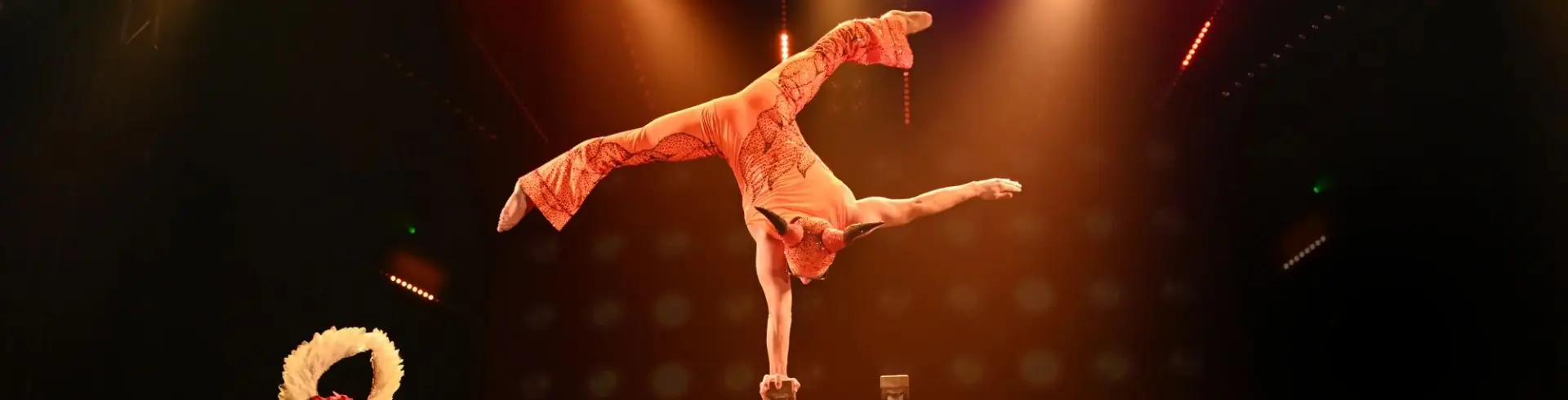 Akrobat mit E Gitarren Spielerin, verkleidet , auf einer Hand stehend