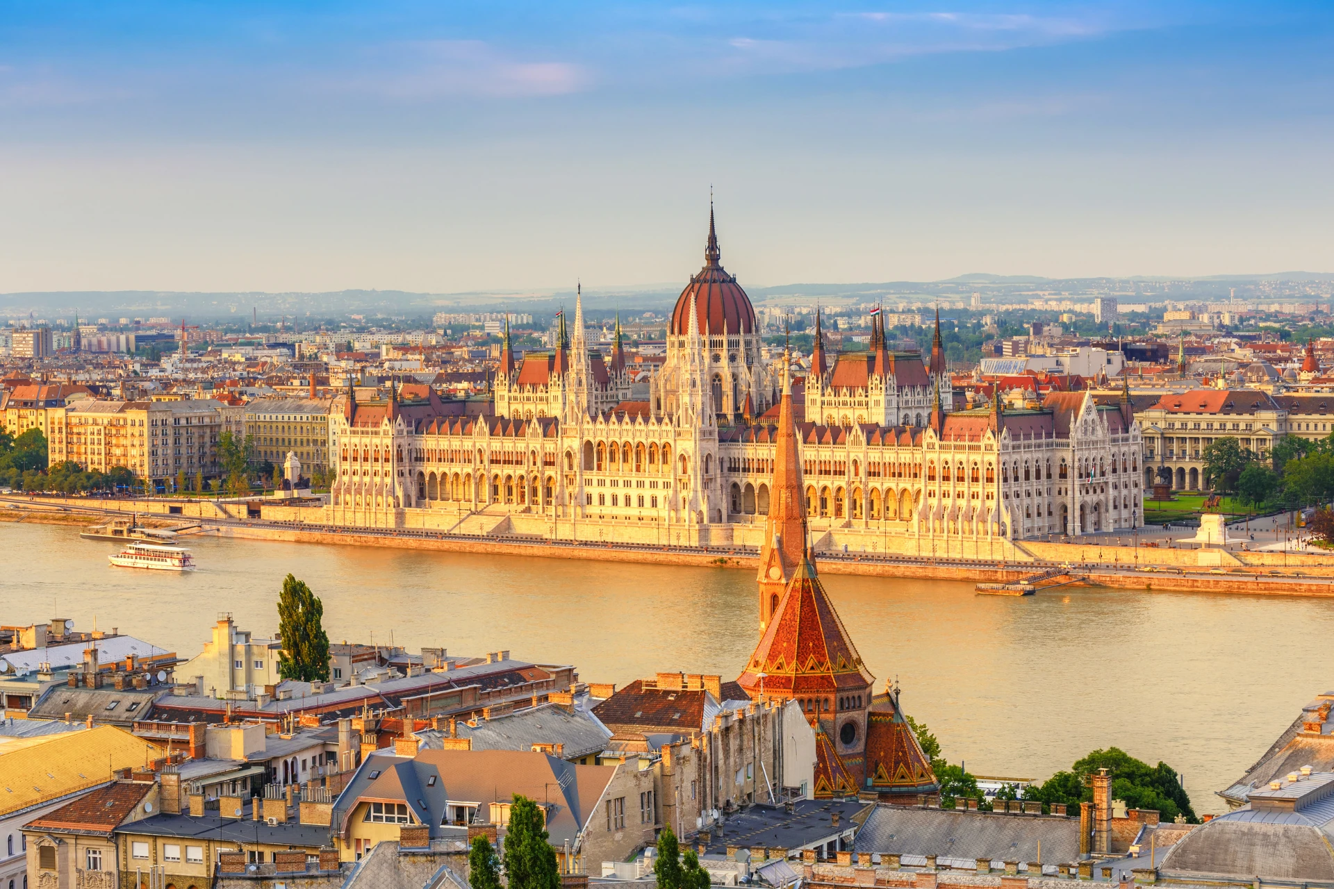 Blick auf das ungarische Parlament am Ufer der Donau in Budapest bei Sonnenuntergang