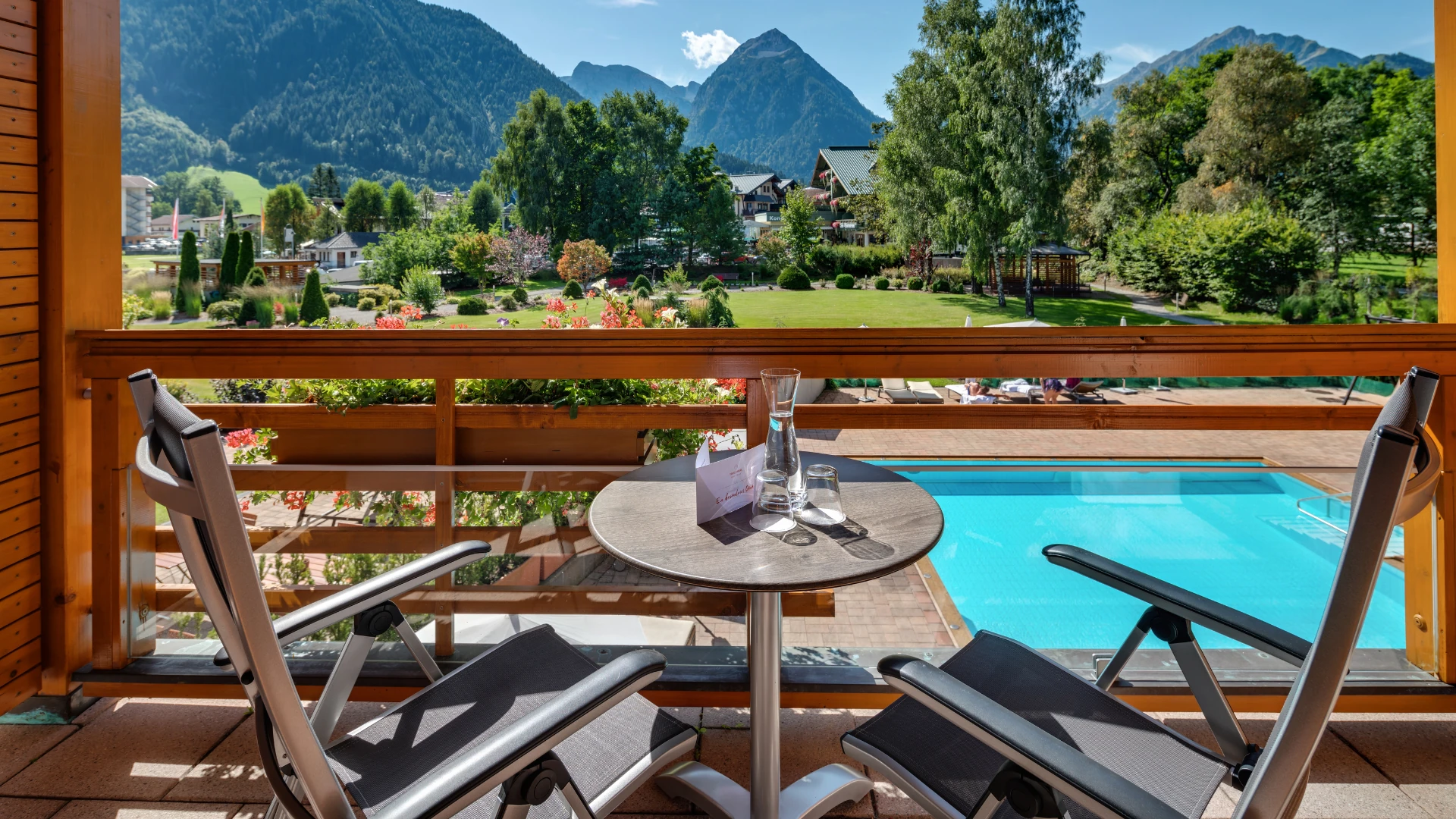 Der Balkon des aja Fürstenhaus am Achensee bietet einen malerischen Blick auf die Berge, den Garten und den Außenpool. Perfekt für entspannte Momente in stilvoller Atmosphäre.