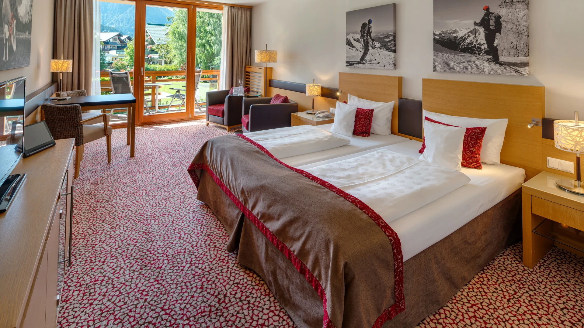 Das komfortable Zimmer im aja Fürstenhaus am Achensee besticht durch ein stilvolles Design mit alpinem Flair, großen Fenstern und einem Balkon, der einen herrlichen Blick auf die Berglandschaft bietet.