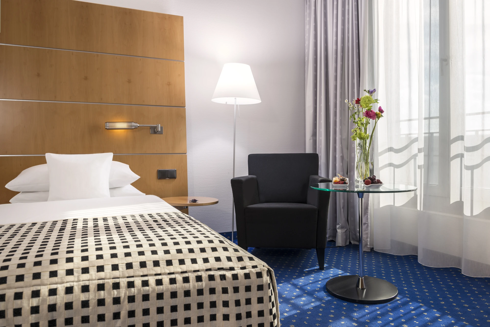 Dorint Hotel Potsdam, Premium-Zimmer Beispiel mit Sessel und Blumen auf einem Glastisch