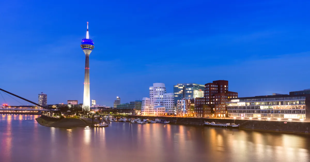 Stadtansicht von Düsseldorf mit dem Rheinufer und der Skyline bei Dämmerung