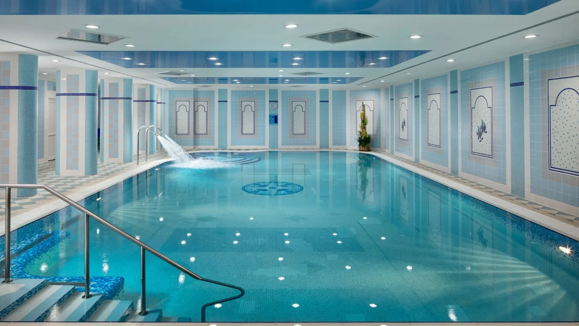 Innenpool im Ensana Hotel Pacifik mit Treppe, Wasserspeier und blau-weißer Fliesenwandgestaltung.