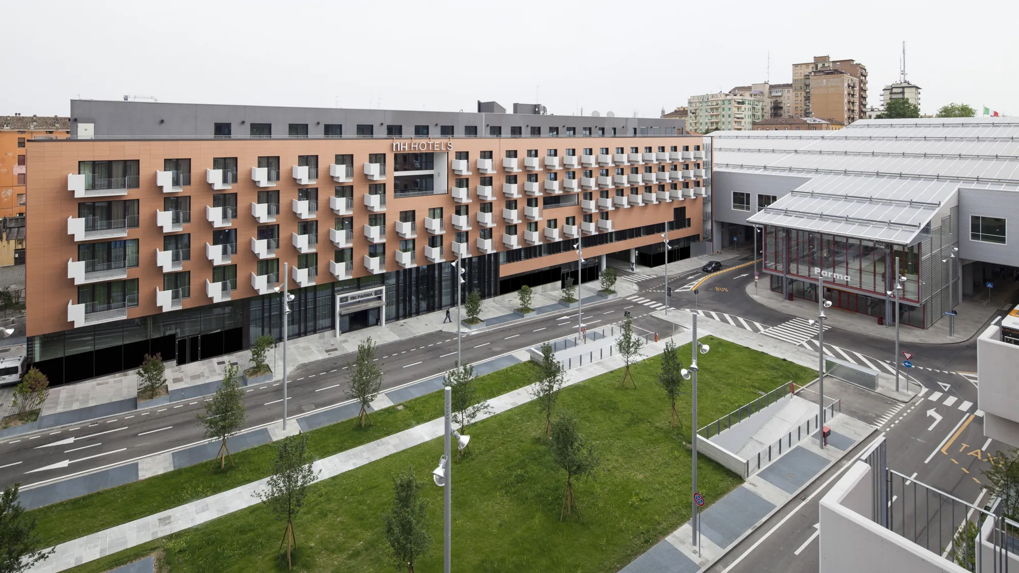 NH Parma - Außenansicht des Hotels umgeben von Grünanlage und weiteren Gebäuden
