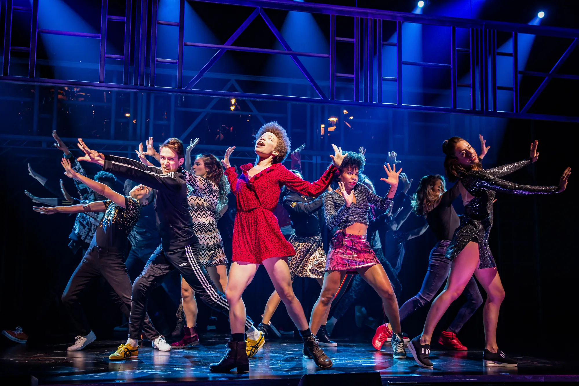 Footloose Musical - Menschengruppe tanzen harmonisch zusammen im Rampenlicht