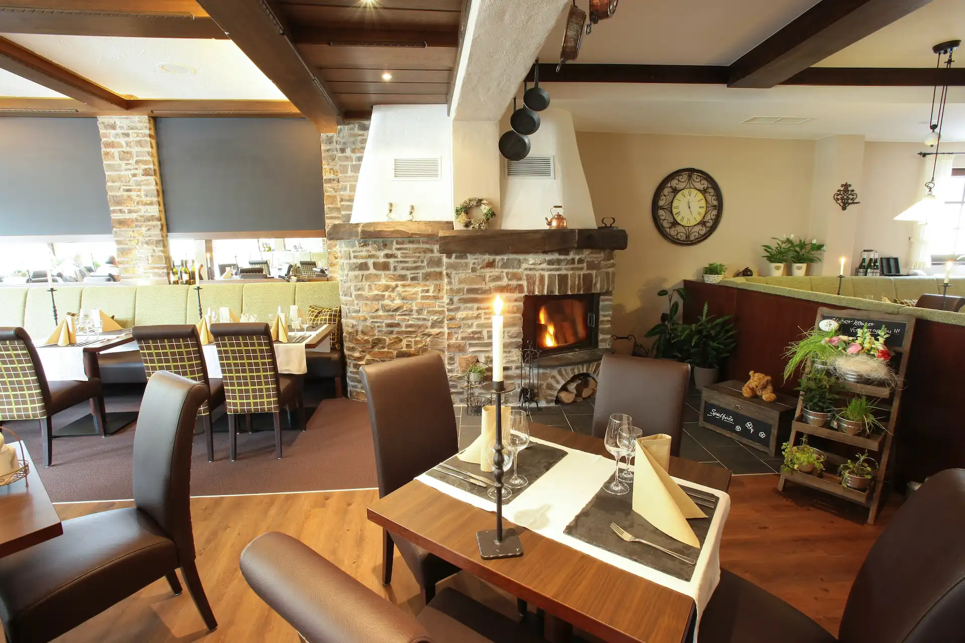 Gemütliches Restaurant mit Kamin, gedeckten Tischen und Stühlen mit karierten Bezügen