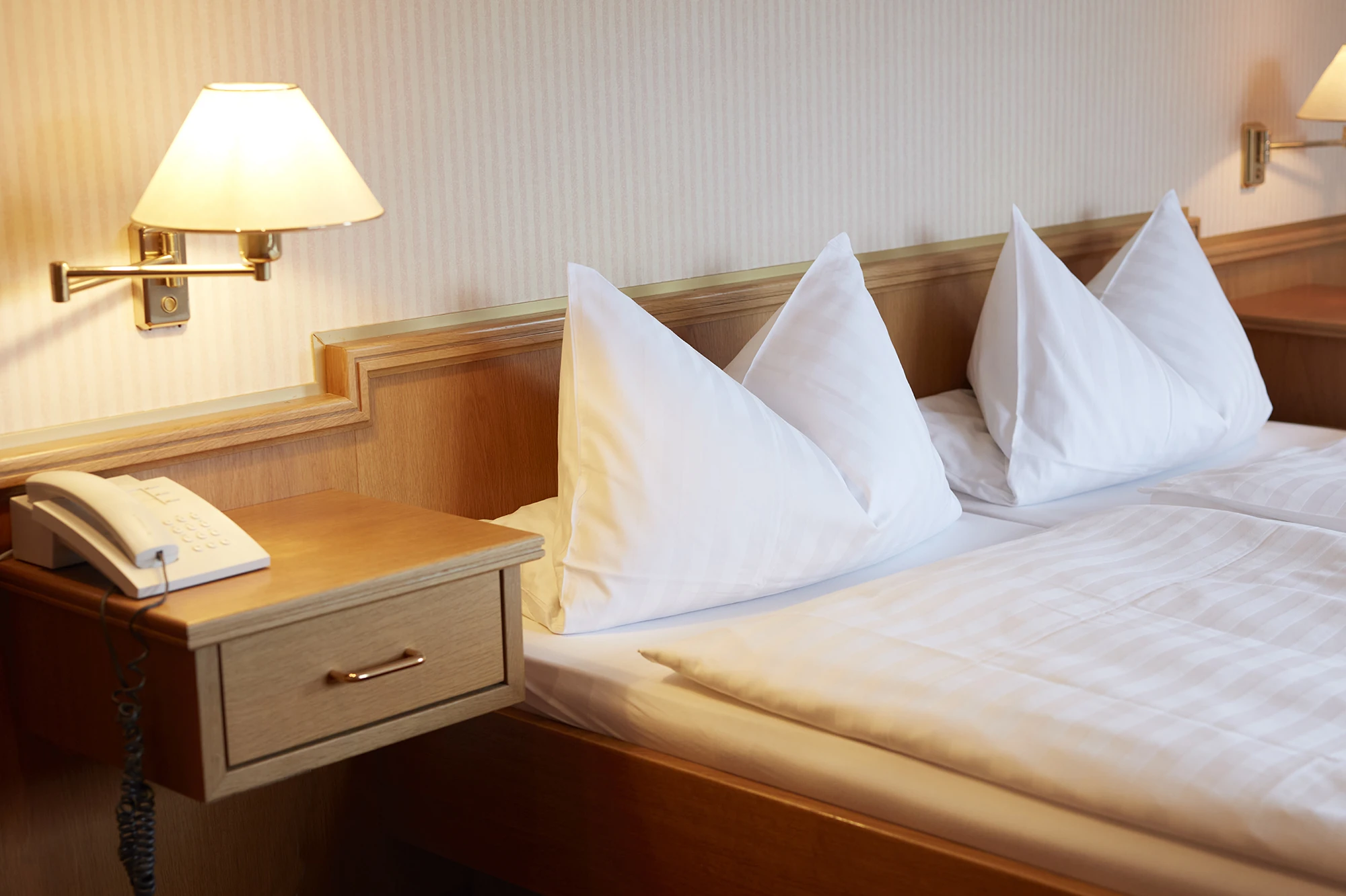 Hotel Störmann - Zimmerbeispiel, Nachttisch und Doppelbett