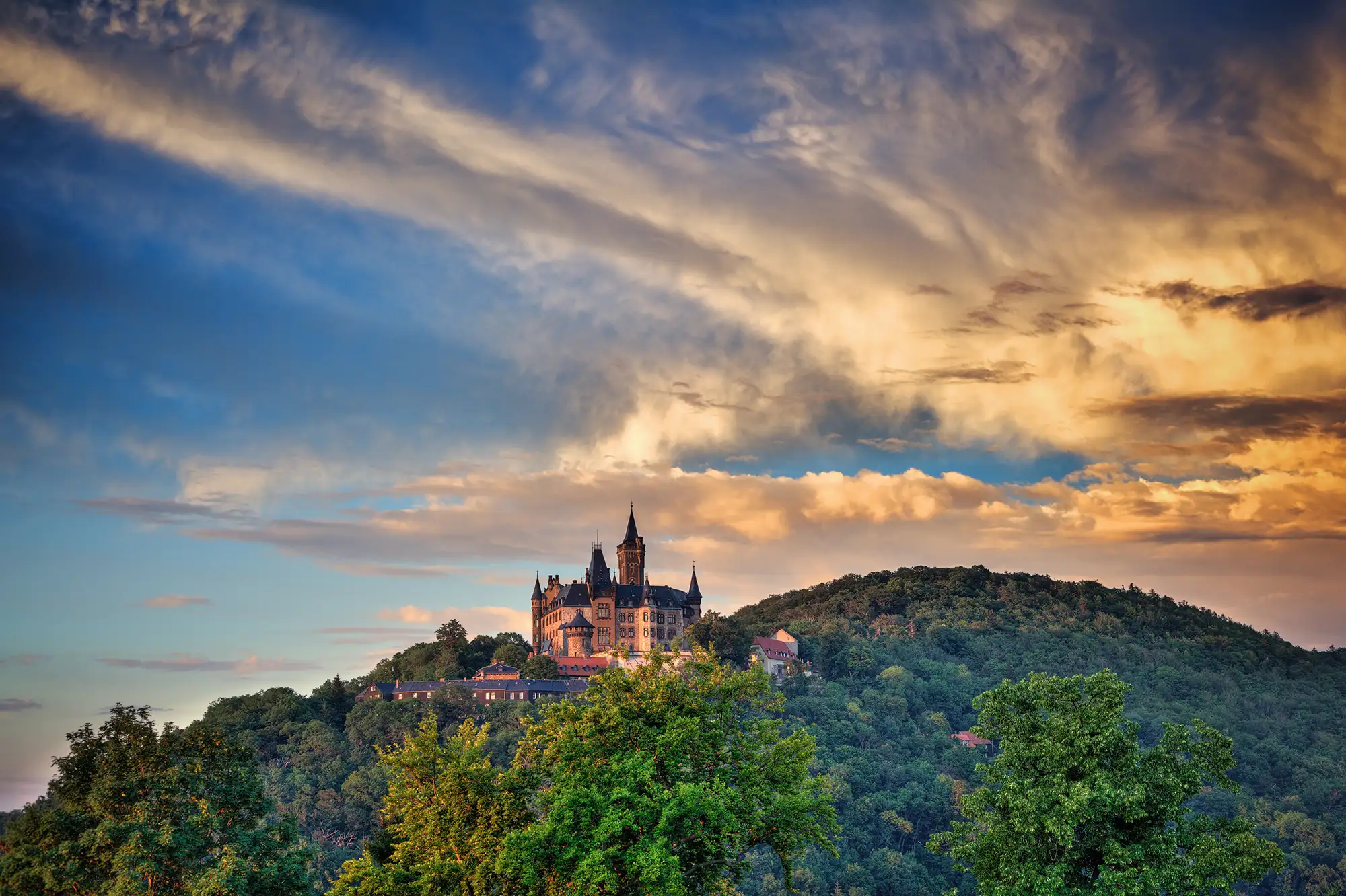 Schloss Wernigerode Berg Himmel blau mit orangenen Wolken