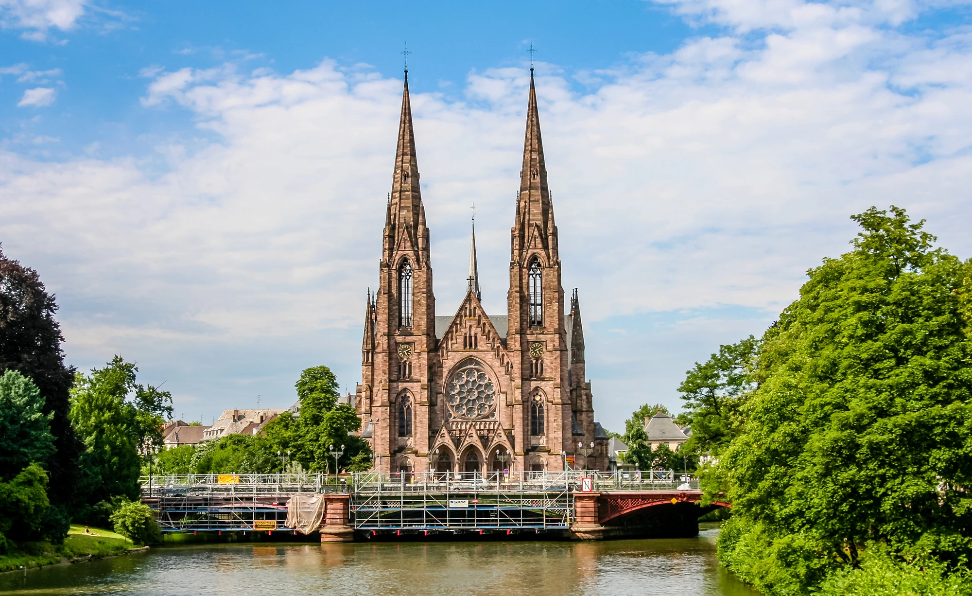 Aussicht auf das Liebfrauenmünster in Strasbourg bei Tageslicht, umgeben von leichten grünen Akzenten der Natur.