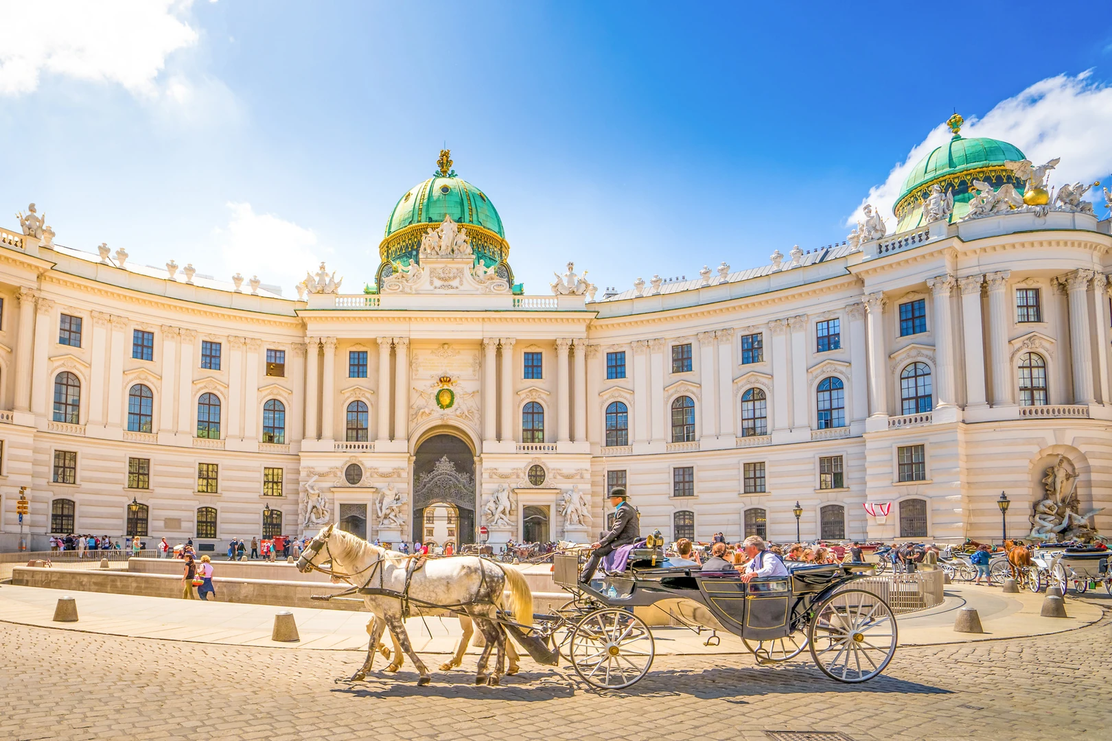 Wien - kaiserliche Alte Hofburg in Wien, weißes Gebäude mit Pferdekutsche im Vordergrund