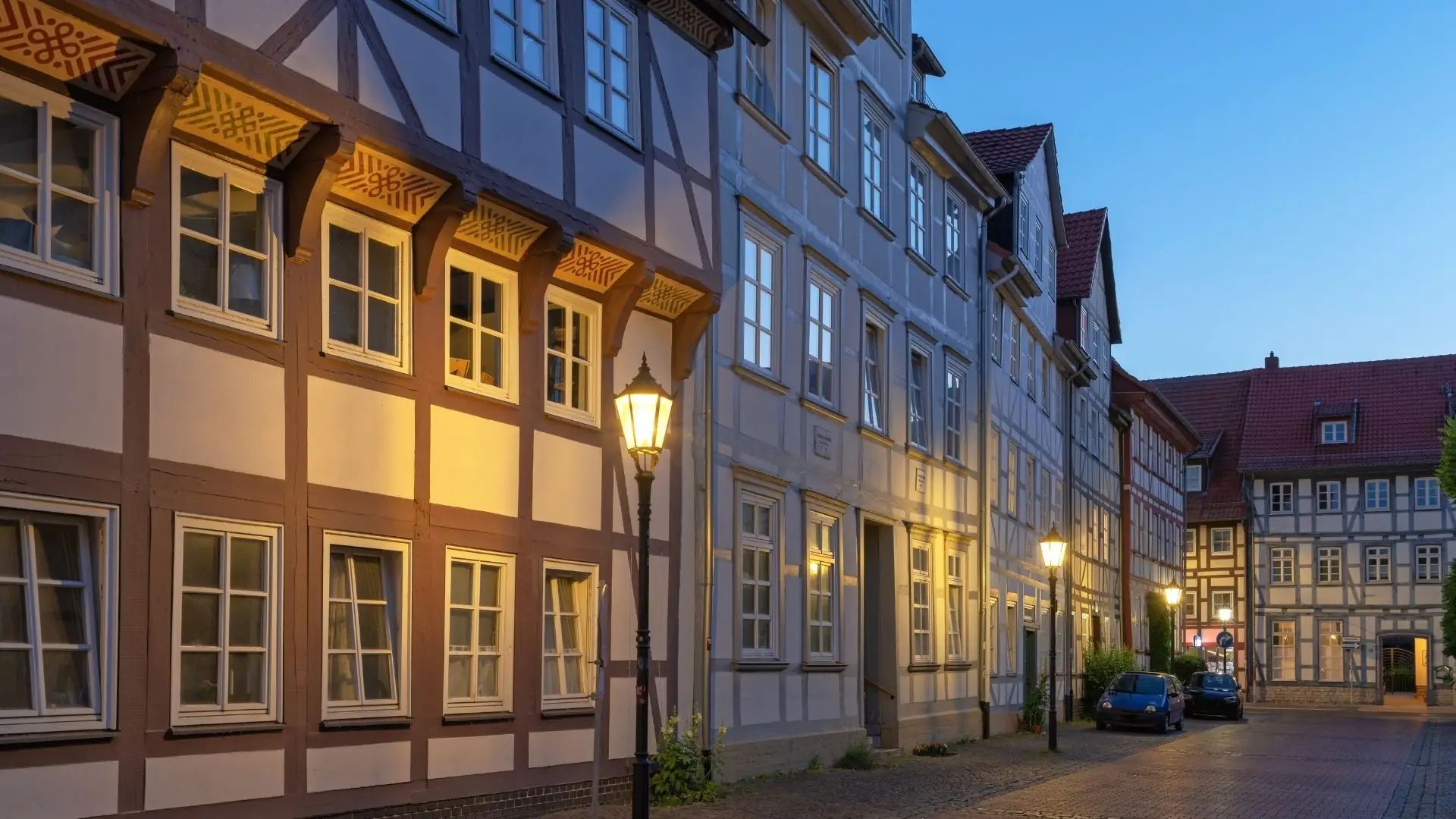 Blick auf die Göttingen-Gasse mit historischen Fachwerkhäusern, beleuchtet von Straßenlaternen. Ein Auto parkt am Straßenrand.