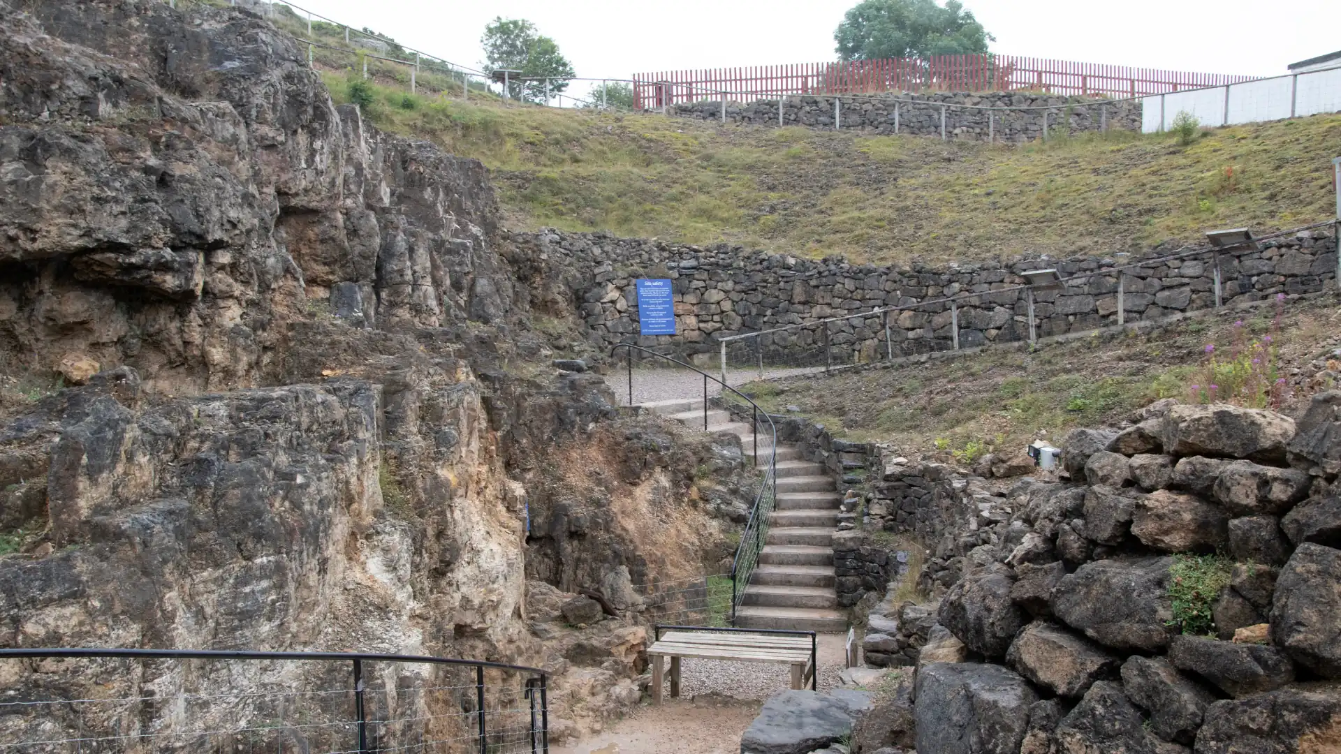 Treppe und Weg zwischen Felsen und Steinmauern in einer historischen Ausgrabungsstätte der prähistorischen Kupferminen Great Orme Copper Mine