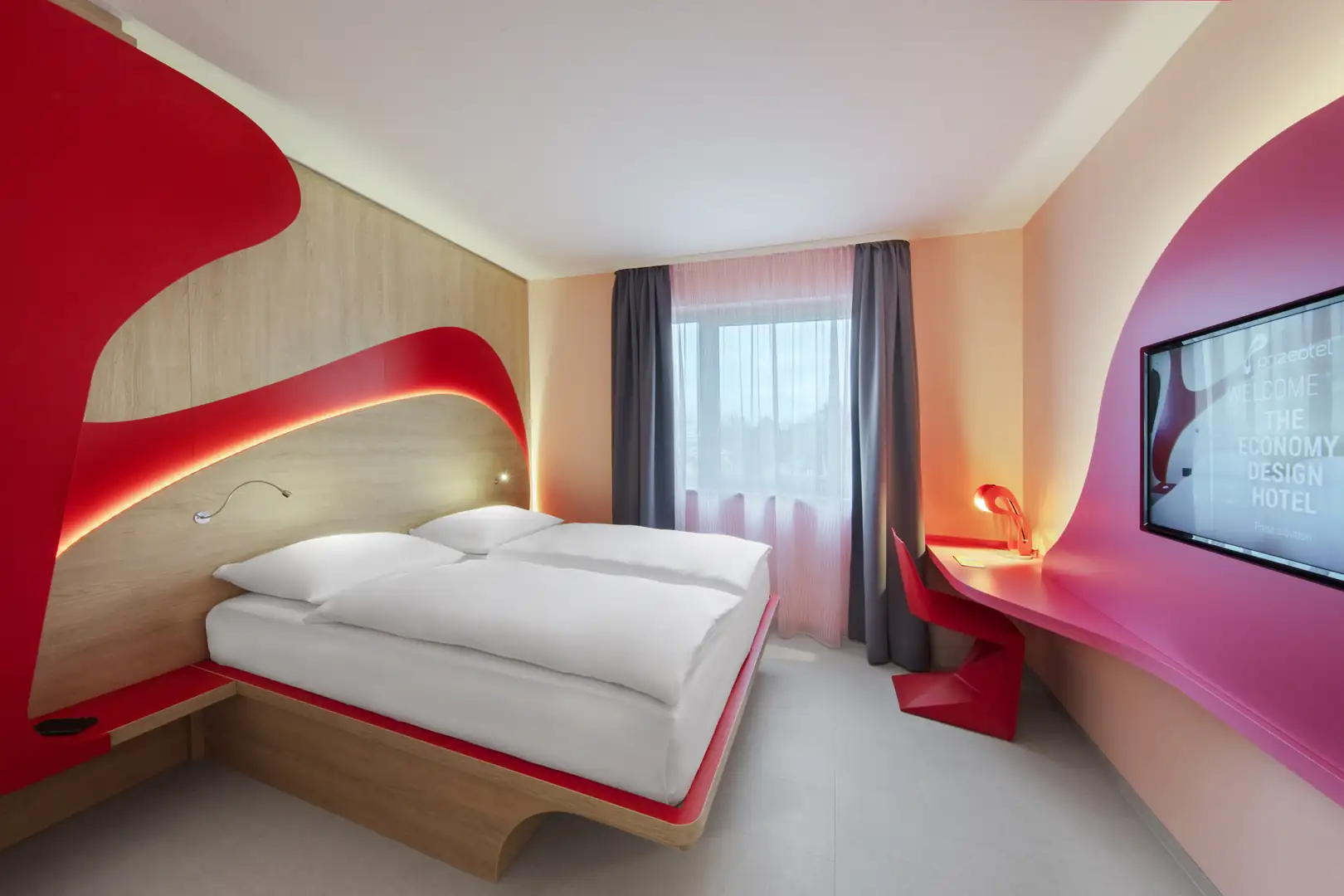 Modernes Hotelzimmer mit rotem Dekor und komfortablem Bett