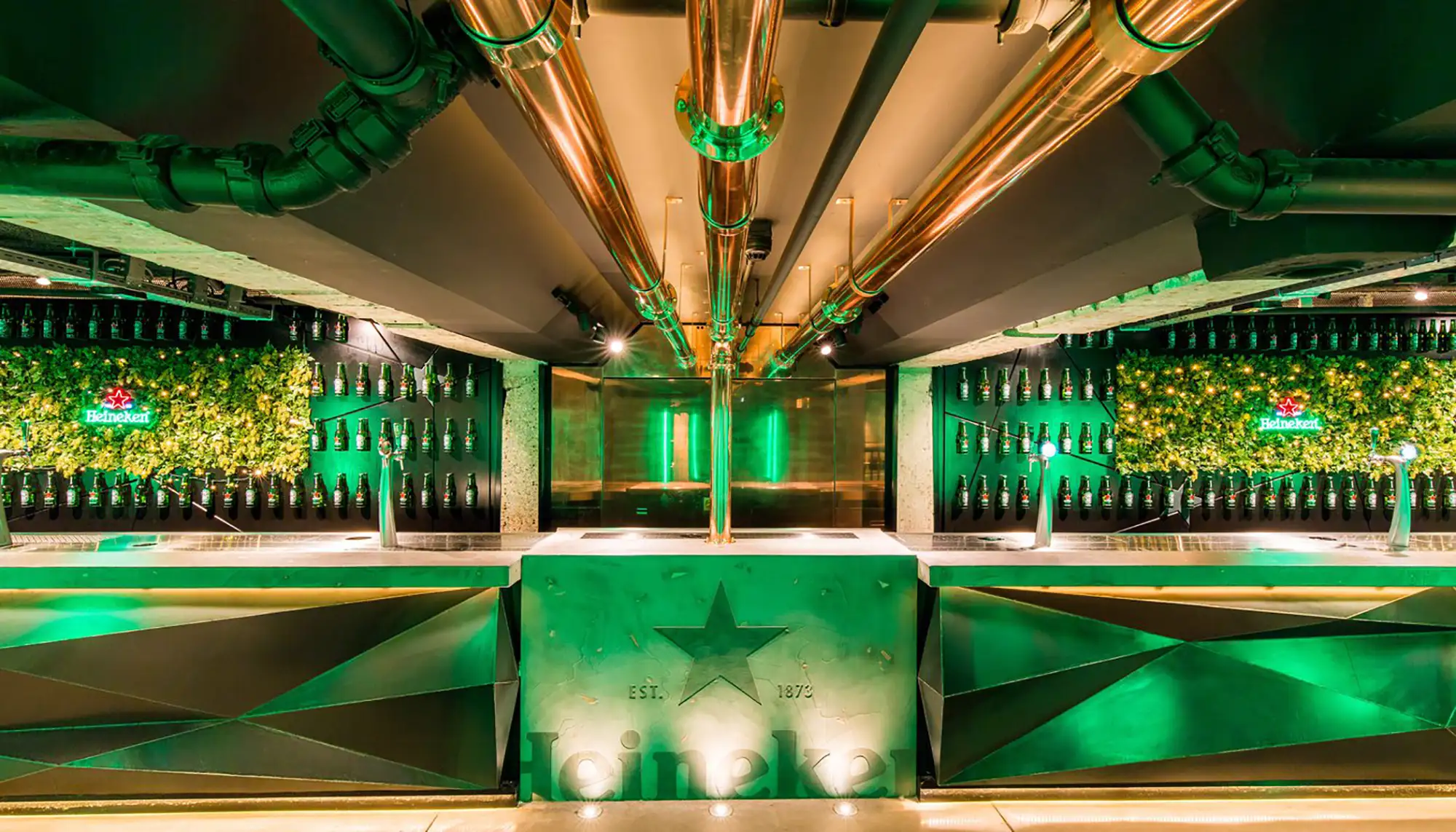 Heineken Museum Amsterdam Theke in der Best Dam Bar mit Zapfsäulen und Flaschen mit grüner Beleuchtung