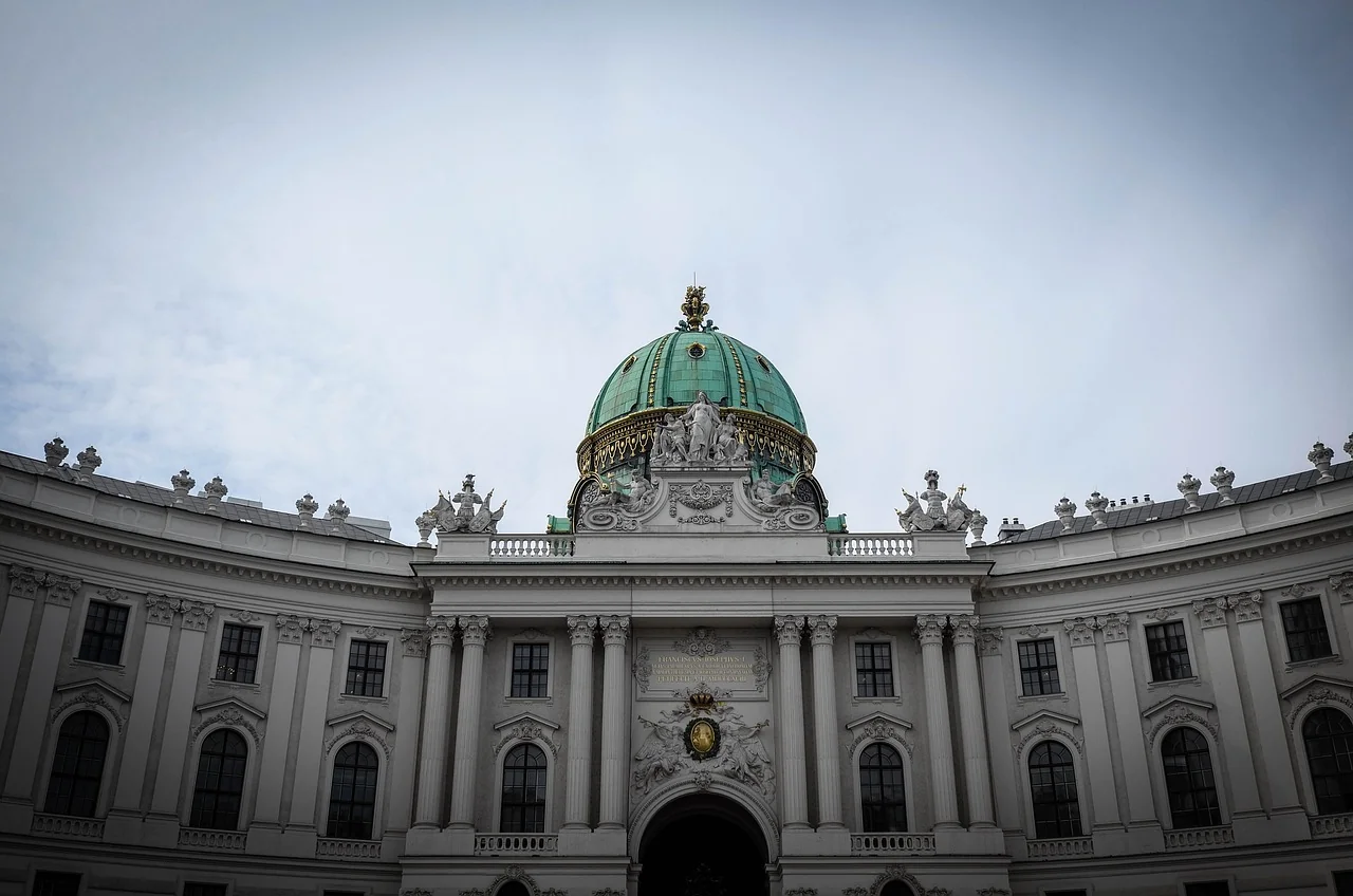 Ansicht der Hofburg in Wien, eine historische Residenz mit grüner Kuppel und beeindruckender Architektur.