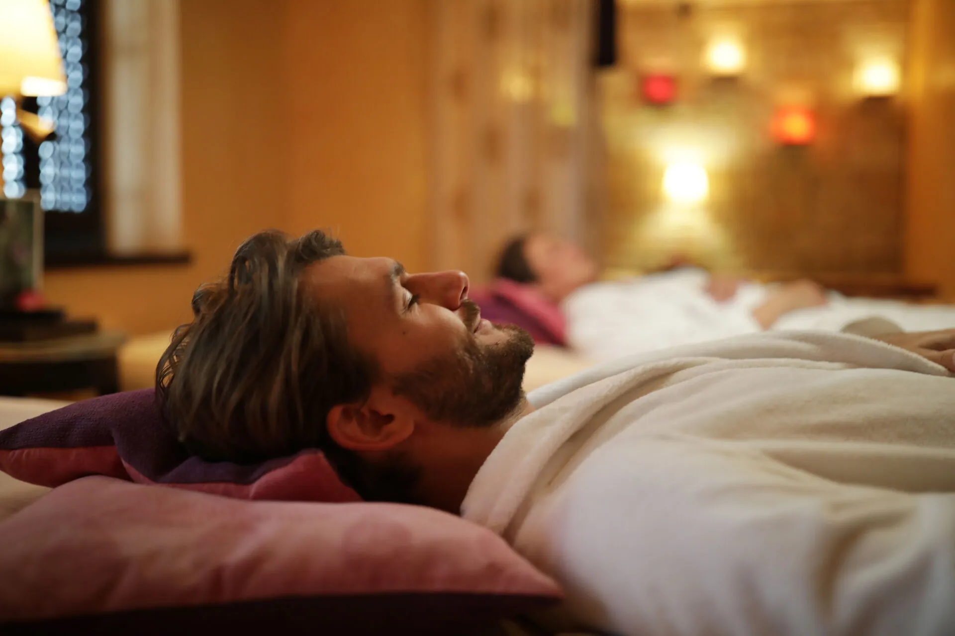 Hotel Die Sonne Frankenberg Wellnessbereich - Mann im Bademantel entspannend am Liegen