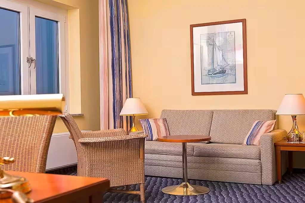 Wyndham Hotel Hansedom Stralsund gemütliches Gästezimmer mit bequemen Möbeln in schlichten Farben und ein schönes Bild an der Wand.