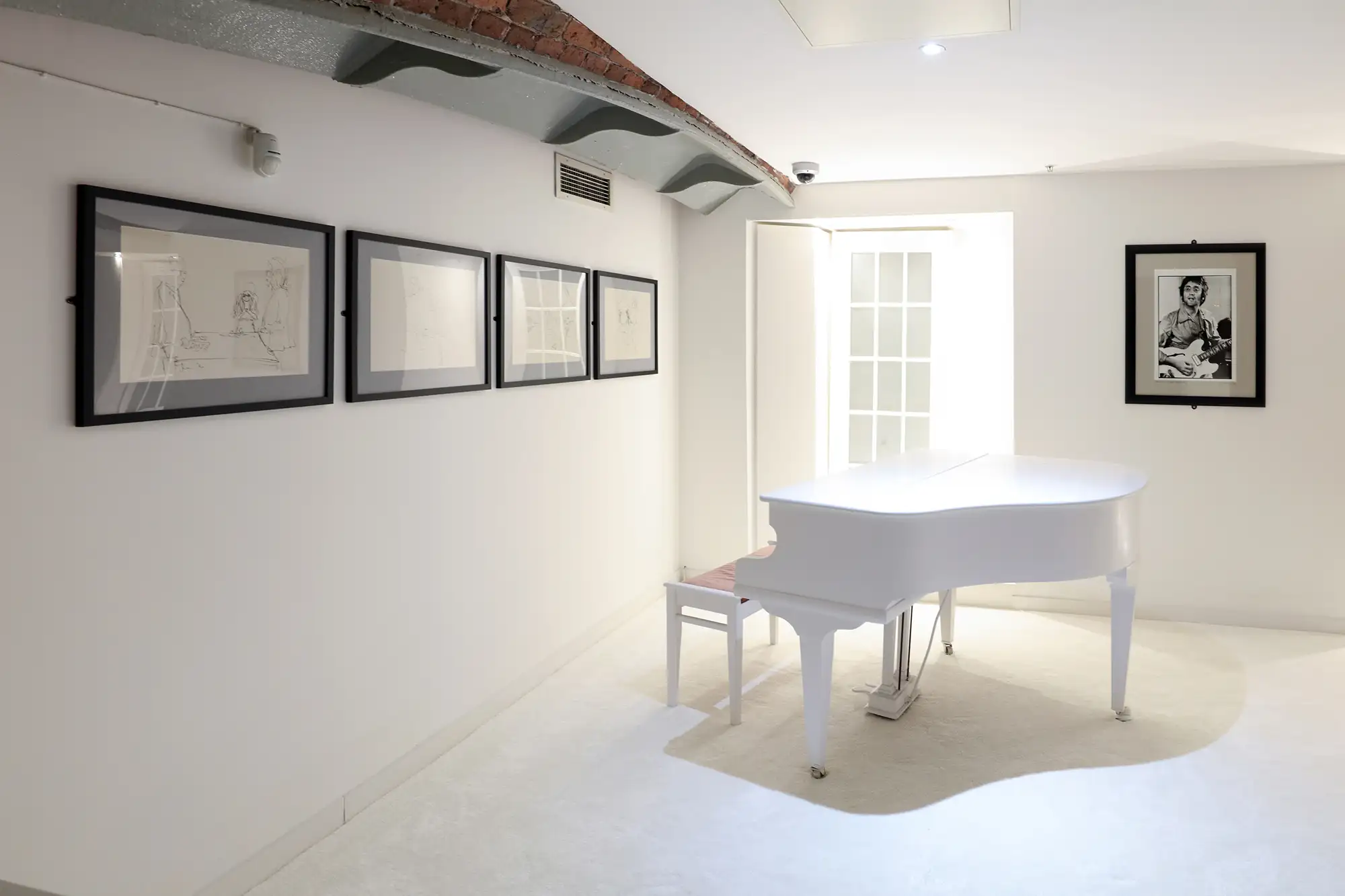 Bild von John Lennon davor ein weißer Flügel im Beatles Museum Liverpool