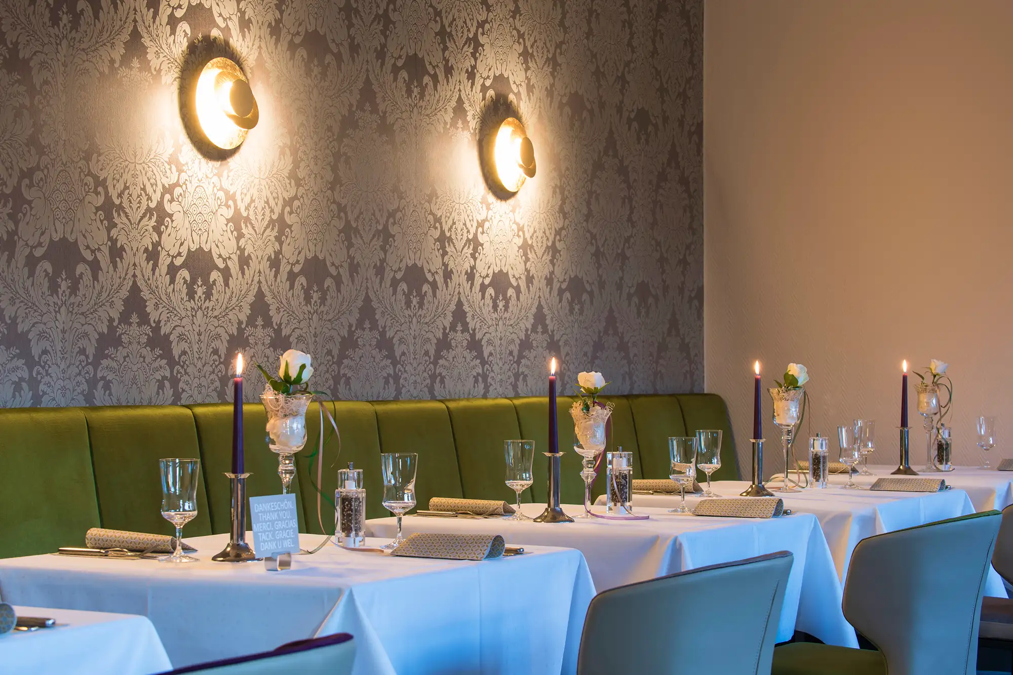 Idingshof Bramsche - Restaurant im Hotel mit gedeckten Tischen mit Stühlen und Bänken und Kerzen