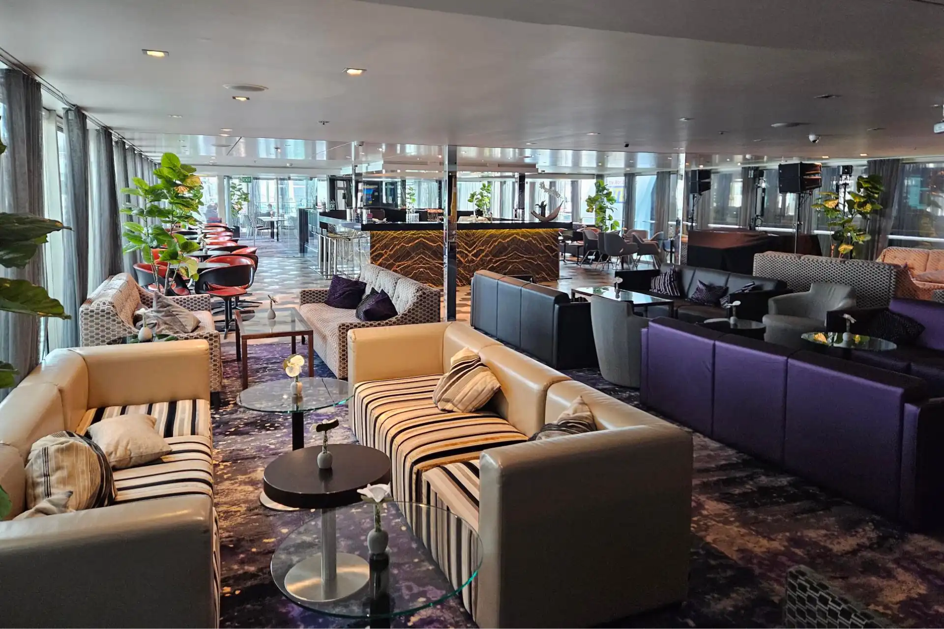 Stilvolle Lounge und Bar auf dem Flusskreuzfahrtschiff KD Moment mit gemütlichen Sesseln, sanfter Beleuchtung und einer großen Getränkeauswahl.