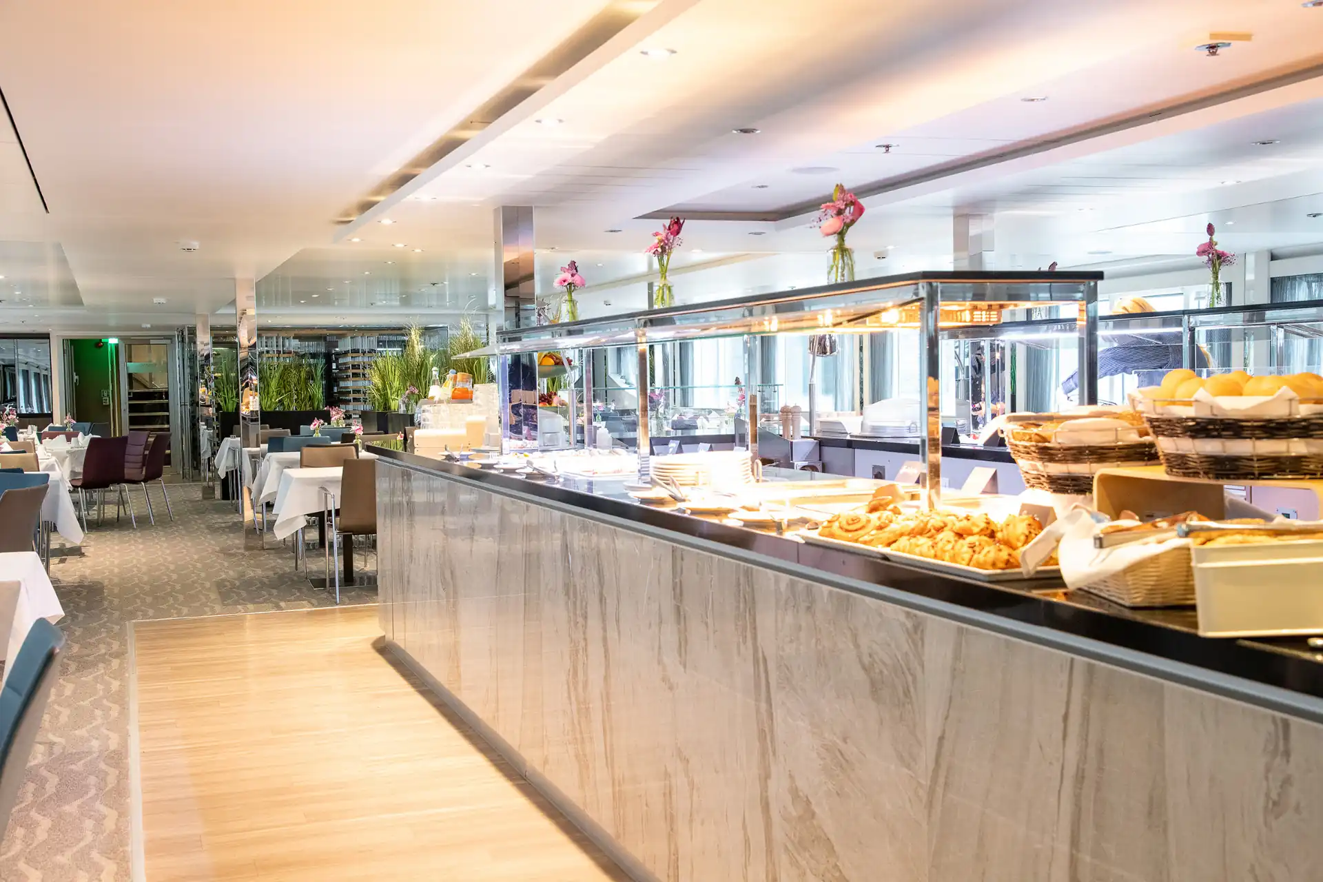 Elegantes Restaurant auf der KD Moment mit geschmackvoll gedeckten Tischen, großen Fenstern und einem stilvollen Ambiente für kulinarische Genüsse während der Kreuzfahrt.