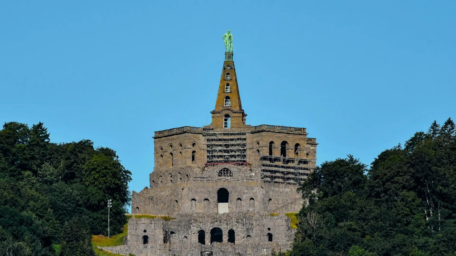 Herkules-Statue auf dem Oktogon im Bergpark Wilhelmshöhe in Kassel, umgeben von Bäumen.