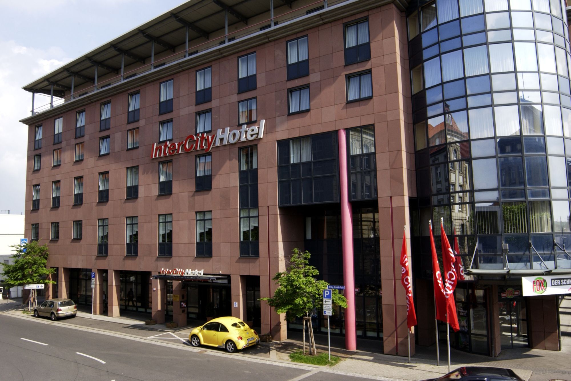 Außenansicht des InterCity Hotel Erfurt, neben einer Straße mit parkenden Autos