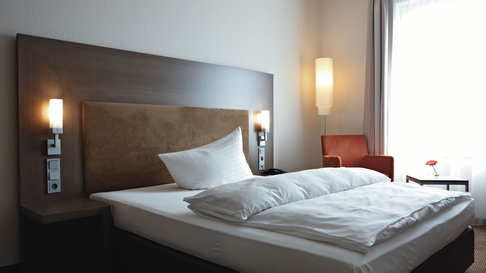 modernes Schlafzimmer mit gemütlichem Bett und Leselampe