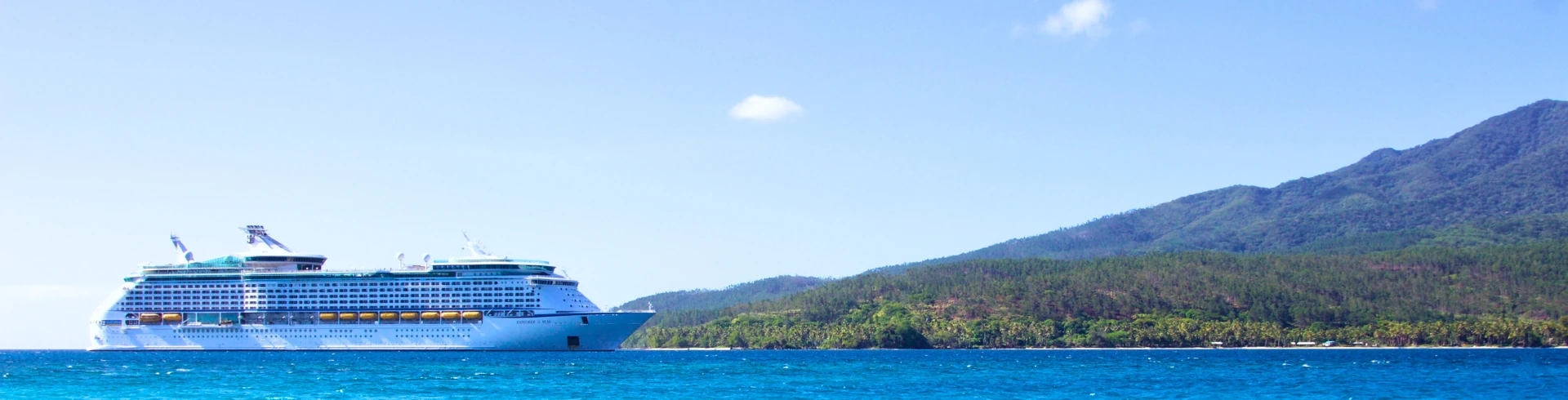 Kreuzfahrt Banner: Kreuzfahrtschiff auf Meer mit Insel davor.