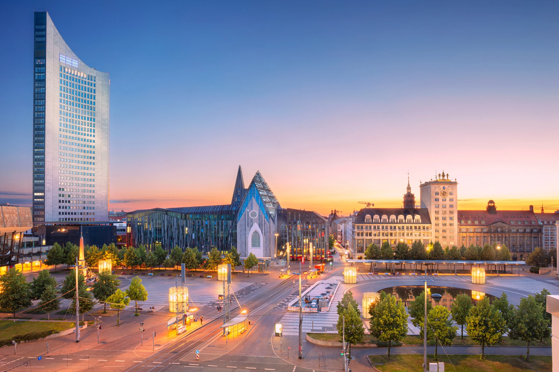 Panoramablick auf Leipzig bei Sonnenuntergang mit modernen Gebäuden.